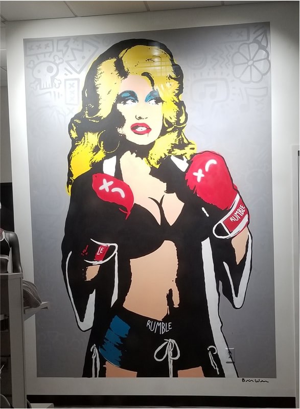 Street art of a woman in boxing gloves and revealing clothing.