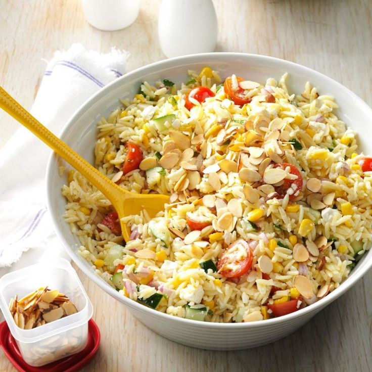 Bowl of colorful vegetable fried rice with a wooden spoon.
