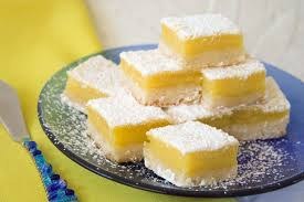 Lemon bars dusted with powdered sugar on a plate.