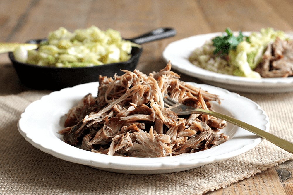 Plate of pulled pork with side dishes in the background.