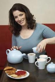 Woman pouring tea from a teapot into a cup.