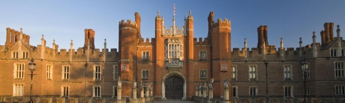 Historic red brick building with ornate towers and a grand archway entrance.