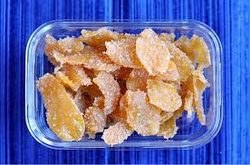 Close-up of crystallized ginger pieces in a container.