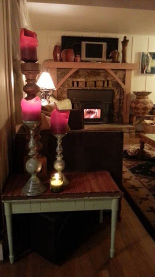 Cozy indoor scene with lit candles and a fireplace.