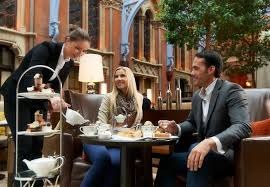Waiter serving coffee to a couple at a cafe.