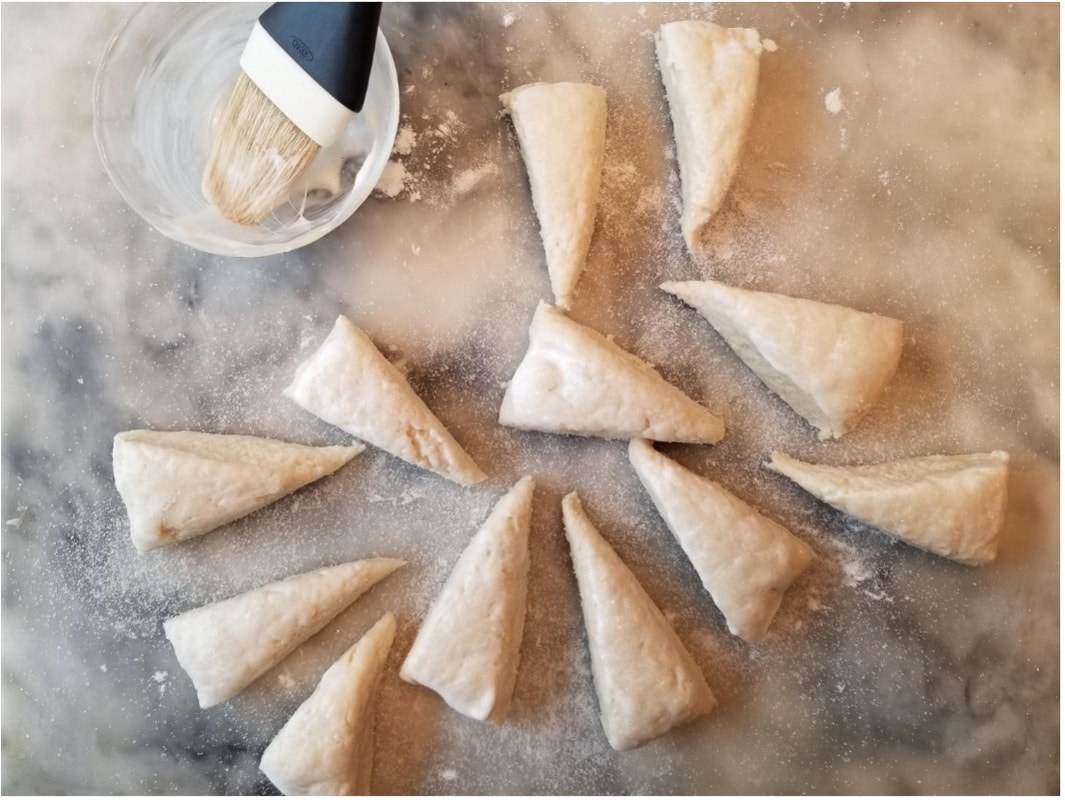 Unbaked pastry cones arranged on a floured surface.
