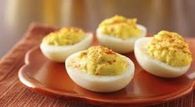 Close-up of deviled eggs on a wooden plate.