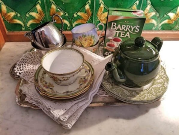 Elegant tea set with cup, saucer, teapot, and Barry's Tea canister.
