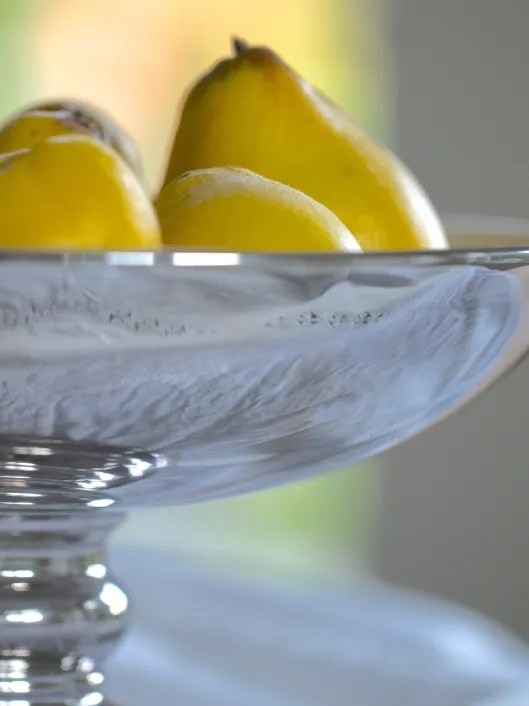 Close-up of a glass bowl with yellow pears.