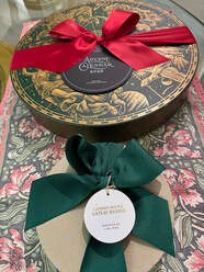 Two gift boxes with decorative bows and tags on a patterned surface.