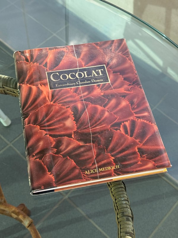 A box of Chocolat dark chocolate with a red floral design.