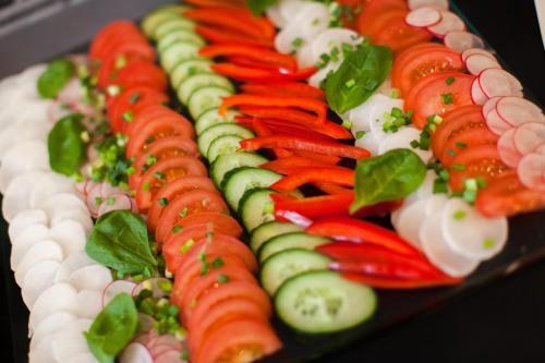 Fresh sliced vegetables arranged in neat rows on a platter.