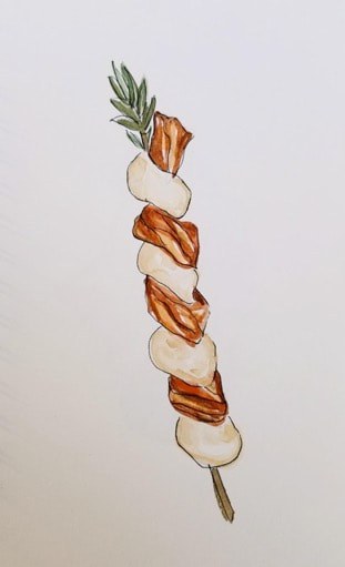 A skewer with alternating pieces of grilled meat and onions.