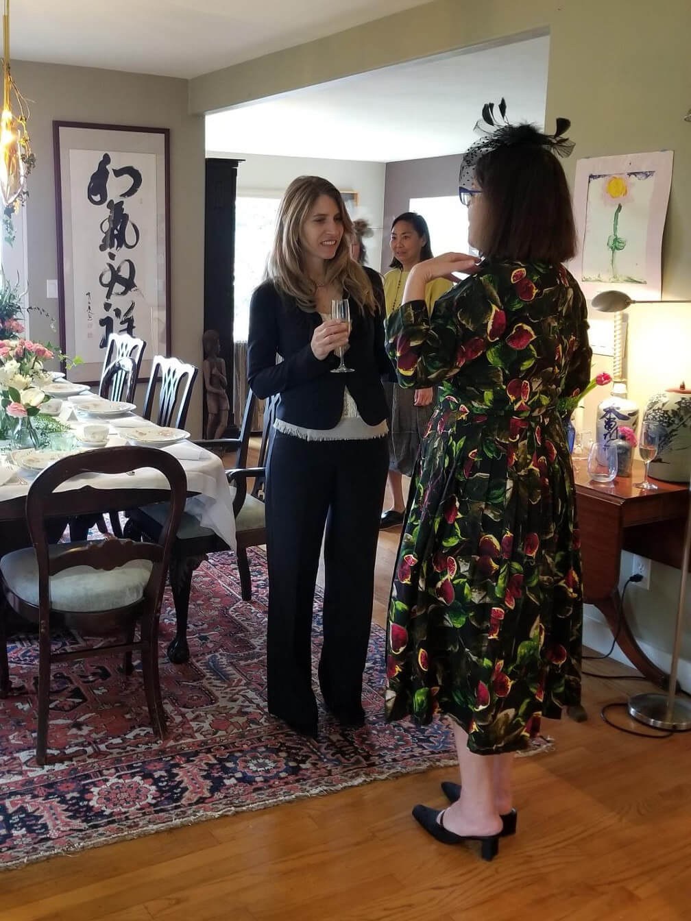 Two women in a cozy, art-filled room having a conversation.