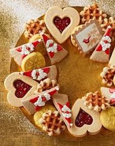 Heart-shaped cookies with red jam and white icing decorations.