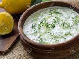 Creamy yogurt dip with fresh dill in a rustic bowl.