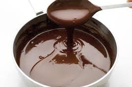 Rich melted chocolate being poured from a spoon.