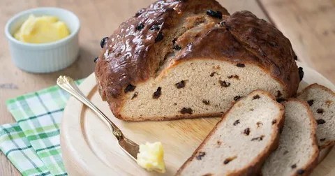 Freshly baked raisin bread with a pat of butter.