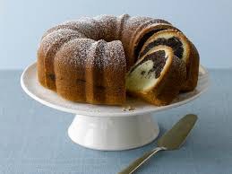 Marble Bundt cake dusted with powdered sugar on a white stand.