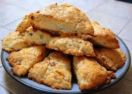 Golden-brown scones stacked on a plate.