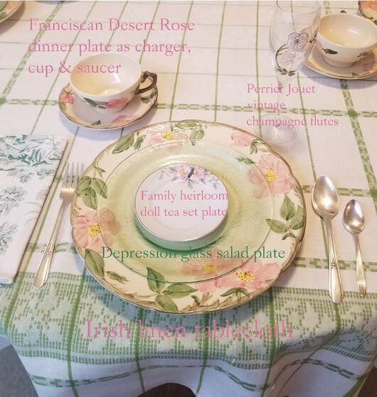 Elegant table setting with floral china and silverware on a checkered tablecloth.