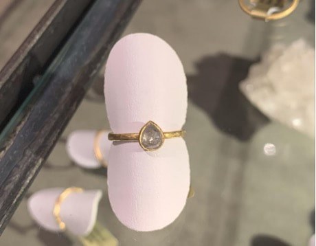Elegant gold ring with a teardrop-shaped gemstone.