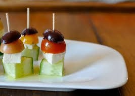 Creative cucumber and olive appetizers with cherry tomatoes on skewers.