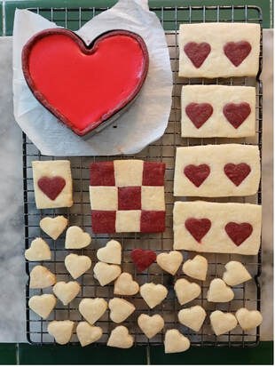 Assorted heart-themed cookies arranged on a cooling rack.
