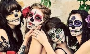 Four people with colorful Day of the Dead face paint posing together.