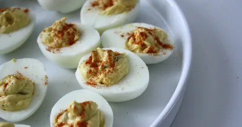 Plate of deviled eggs garnished with paprika.