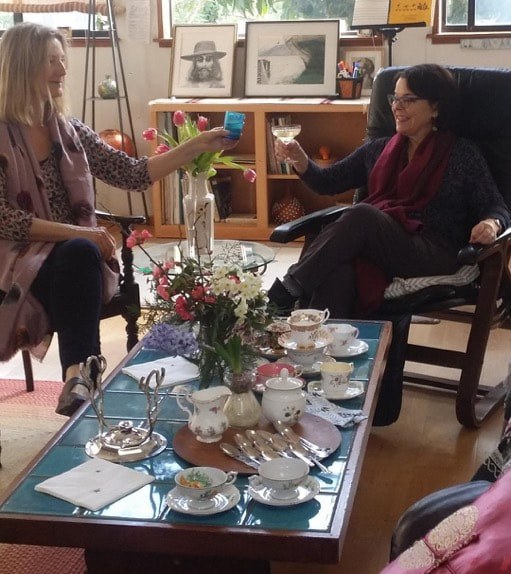 Three women enjoying tea and conversation in a cozy living room.