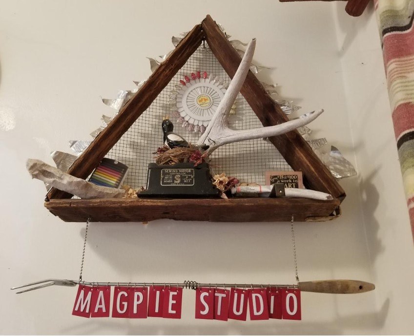 Rustic wooden shelf with clock and decorative items under a triangular frame.