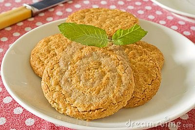 A plate of golden brown cookies garnished with mint leaves.