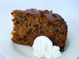 Slice of carrot cake with cream on the side.