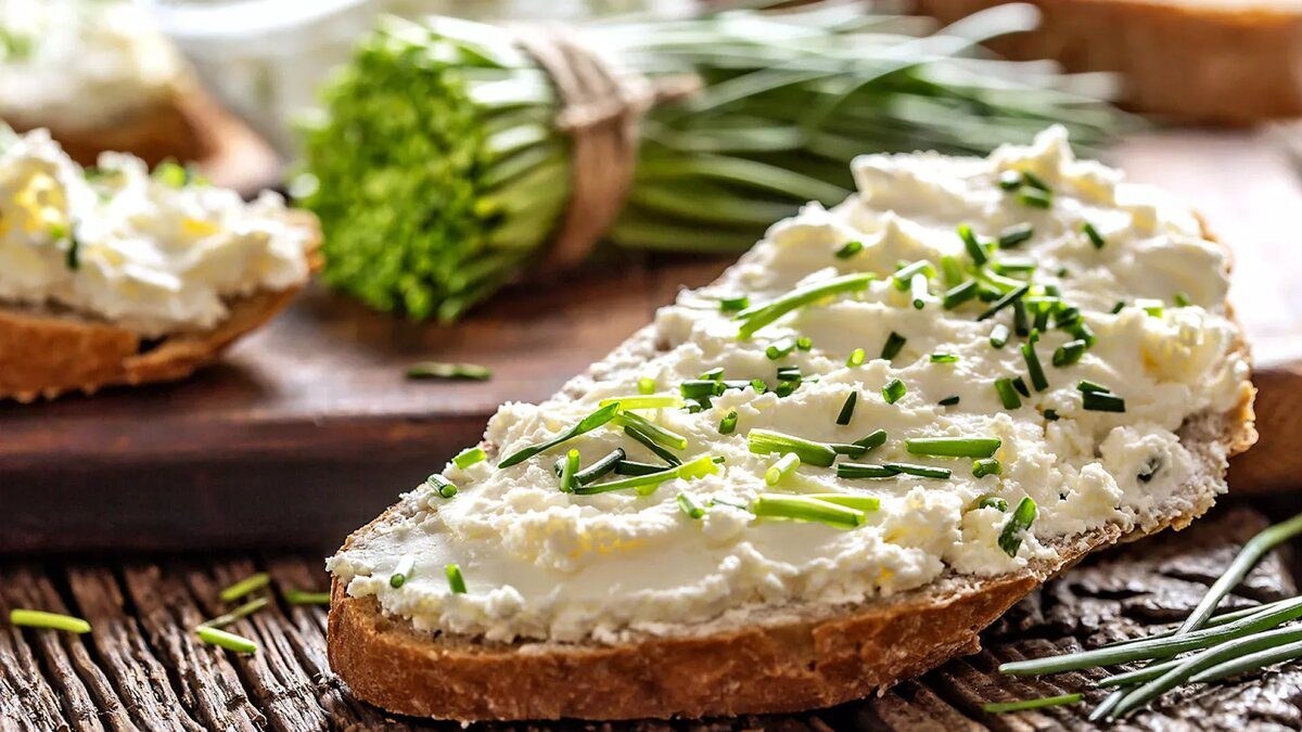 Cream cheese spread on bread topped with fresh chives.