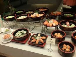 Assorted sushi rolls and nigiri beautifully arranged on black plates.