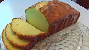 A sliced loaf of yellow pound cake on a lace tablecloth.