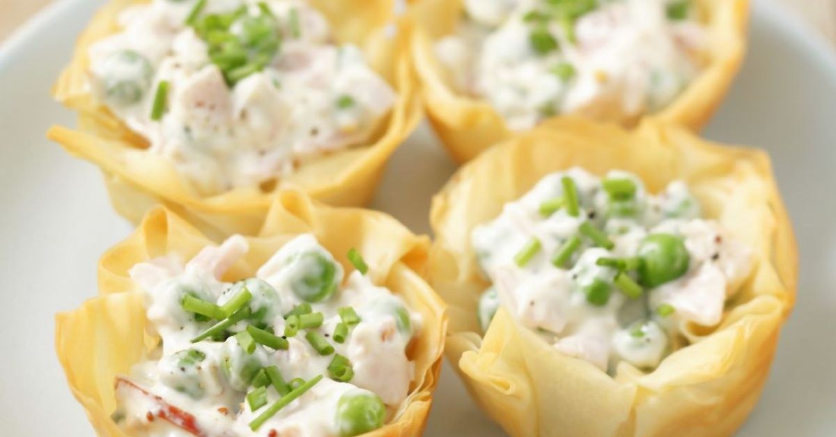 Mini tartlets filled with creamy chicken salad and topped with chopped chives.
