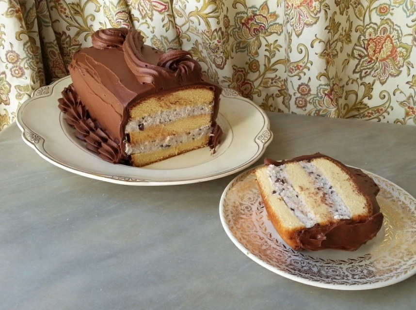 A slice of layered chocolate cake with caramel filling on a plate.