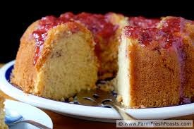 A slice of moist cake with raspberry topping on a plate.