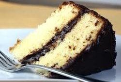 Slice of vanilla cake with chocolate frosting layers.