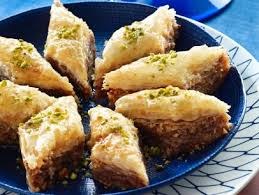 Plate of golden, crispy baklava pieces garnished with crushed pistachios.