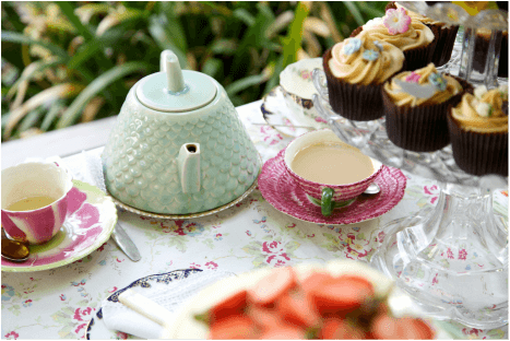 Elegant tea setting with cupcakes and fresh strawberries.
