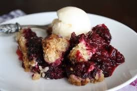 A berry crumble dessert topped with a scoop of vanilla ice cream.