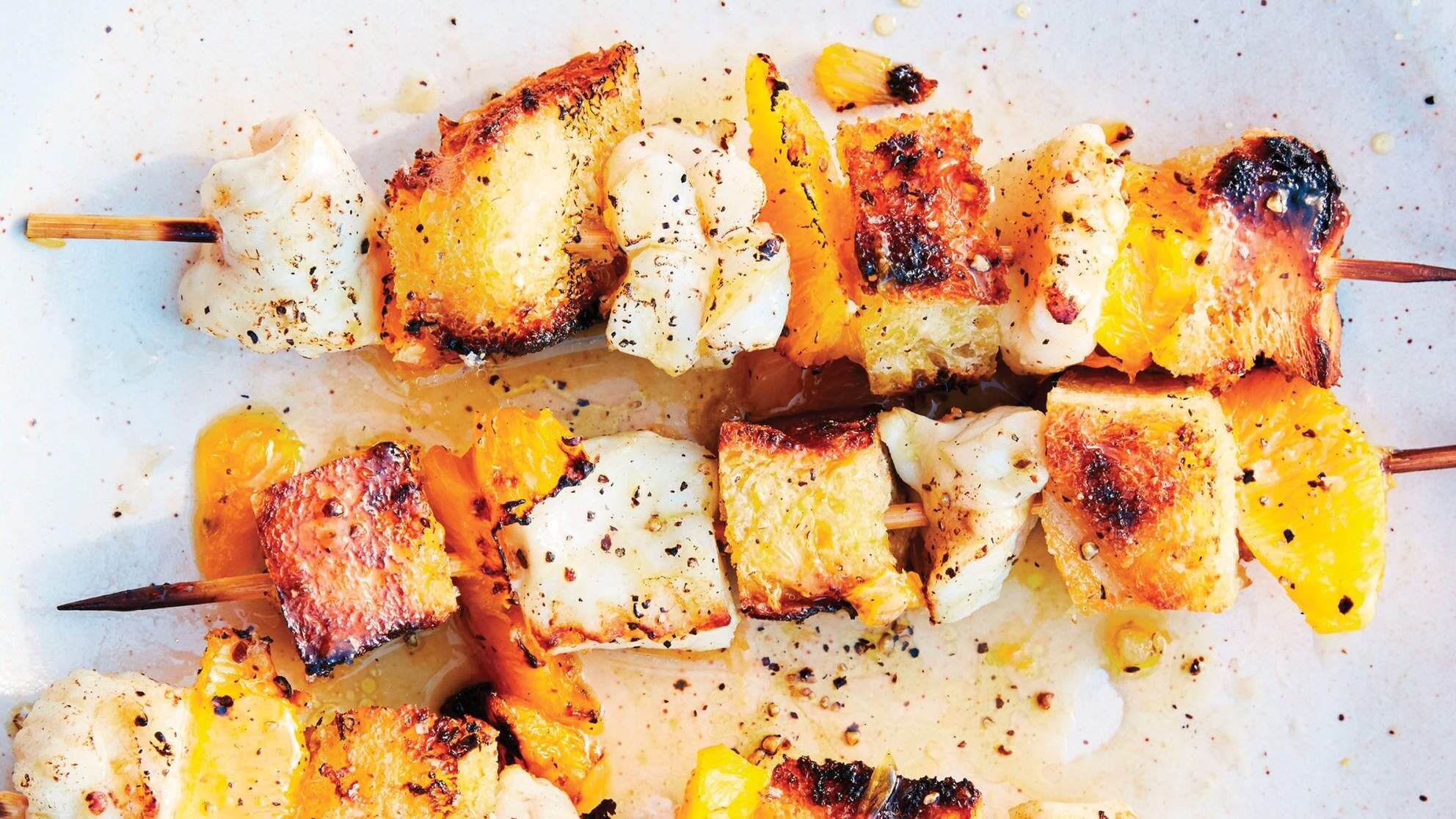 Grilled bread cubes with herbs and seasoning on parchment paper.