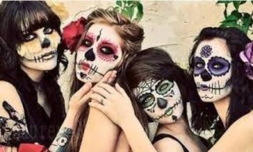 Three people with artistic skull face paint posing together.