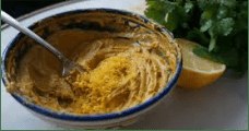 Bowl of seasoned butter with lemon zest and herbs.