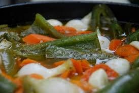 Close-up of a cooked vegetable dish with carrots, green peppers, and onions.