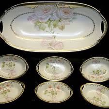 Elegant porcelain serving platter and six matching bowls with floral designs.