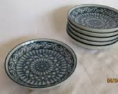 Stack of decorative ceramic plates with intricate patterns.